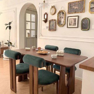 Альтернативный интерьер с другим вариантом обеденного стола и зелёными бархатными стульями, демонстрирующий возможные сочетания отделки и материалов.