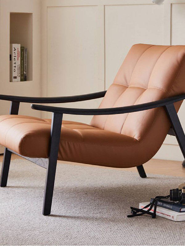 Кресло из ясеня в кожаном варианте светло‑коричневой кожи; общий вид спереди, демонстрация объёма сиденья и мягкой набивки на фоне интерьера.