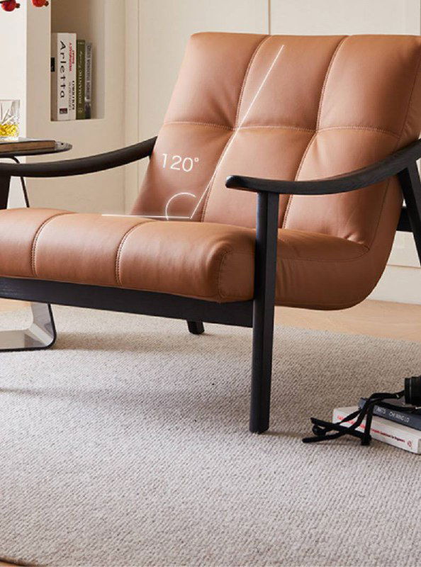 Крупный ракурс кожаного кресла, вид на сиденье и спинку с фокусом на стежку; демонстрация качества и текстуры кожи и формы.