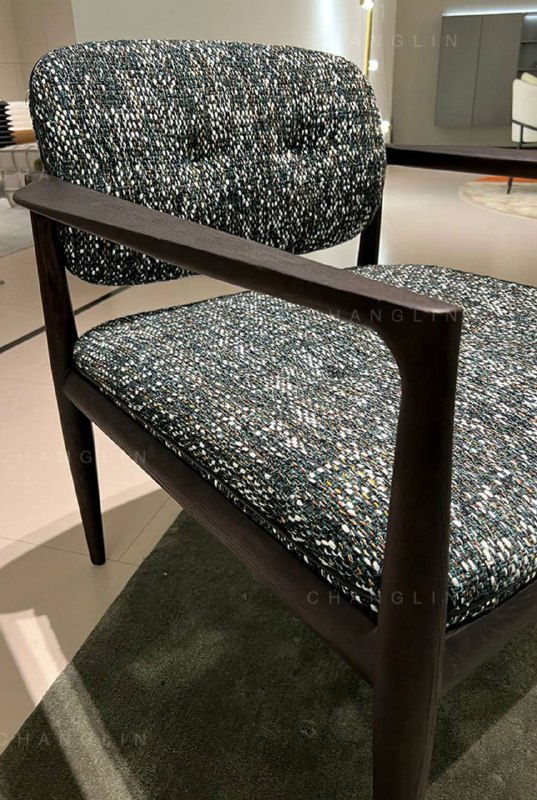 Крупный план спинки кресла и подлокотника: натура цвета дерева, аккуратная обработка кромок и мягкая ткань с мелким рисунком.