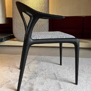 Боковой ракурс деревянного стула из массива ясеня с изящной изогнутой спинкой и тканевой сидушкой в интерьере шоурума.