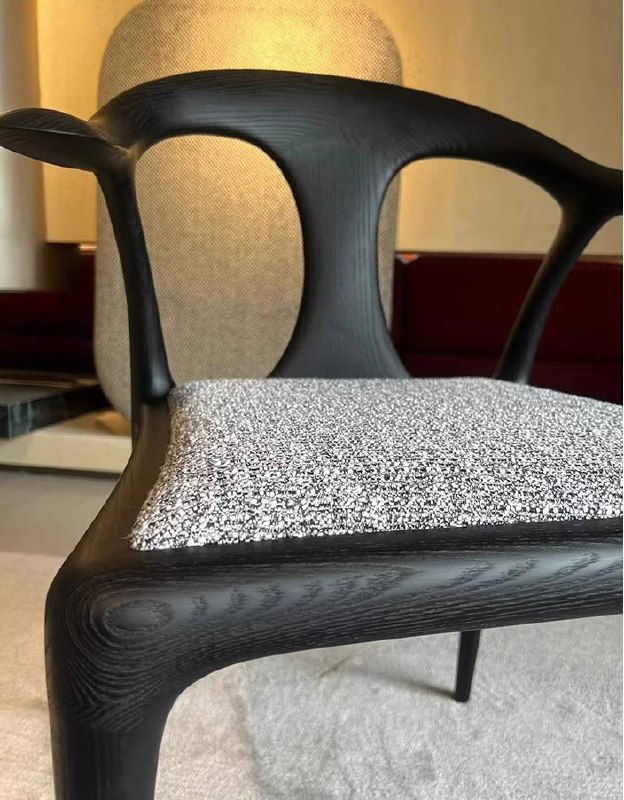 Крупный план сиденья стула: текстура ясеня на рамке и серо-белая тканевая обивка сидушки с заметной структурой материала.