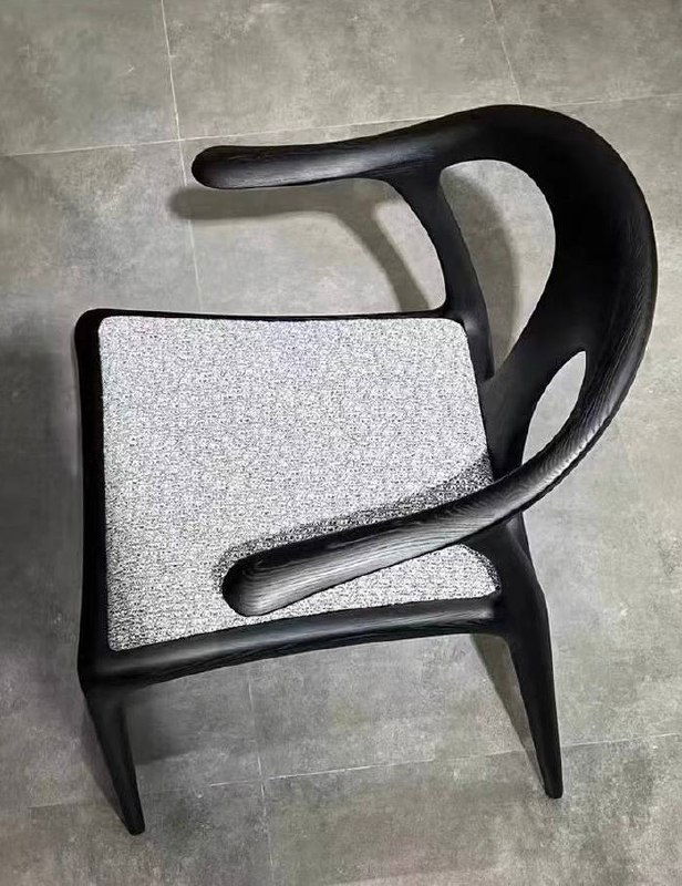 Вид сверху на стул из ясеня: форма спинки и сиденья, окружение плиточного пола, подчёркивающее контуры изделия.