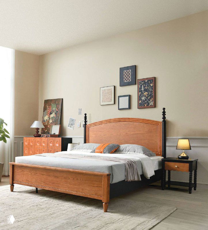 Кровать с полукруглым резным изголовьем и контрастной тёмной базой, интерьерная сцена с прикроватными аксессуарами и картинами на стене.