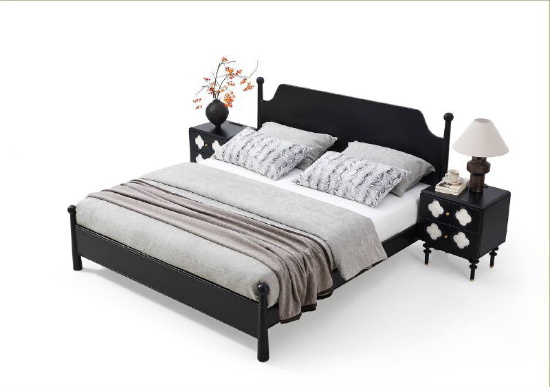 Кровать с чёрной рамой и декоративными ножками на белом фоне, показана в студийной съёмке с аксессуарами для каталога производителя.