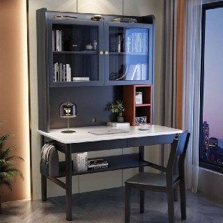 Серый письменный стол с контрастной столешницей: полки для книг, настольная лампа и стул в углу рядом с большим окном.