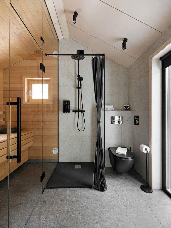 Современная ванная с душевой зоной и элегантной плиткой, чёрные элементы сантехники и компактная планировка, интерьер сауны рядом.