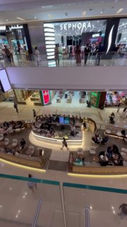 Вид с верхнего этажа на островные кофейные точки и посетителей, открытая планировка фудкорта в Marina Mall.