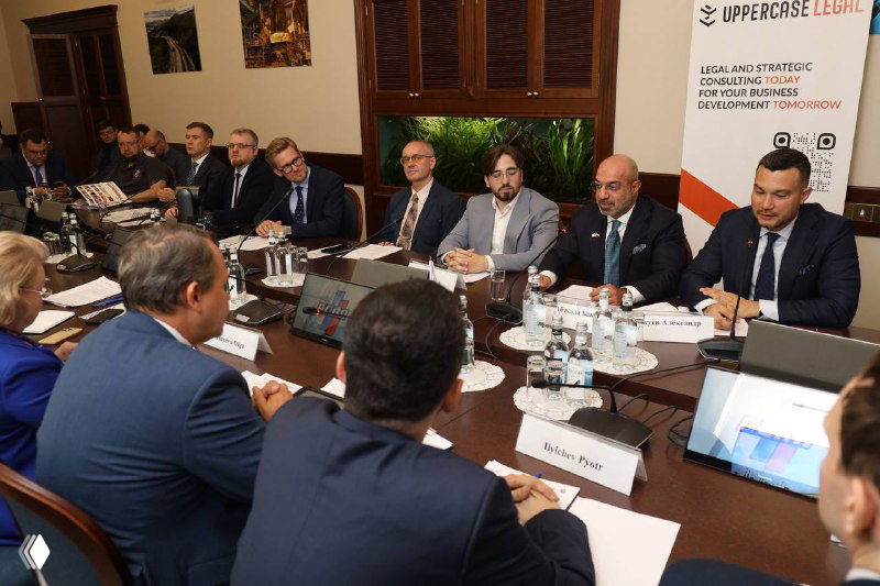 Широкий план зала заседаний: делегаты Dubai Chambers и российские представители за круглым столом ведут переговоры и делают заметки на планшетах и бумаге.