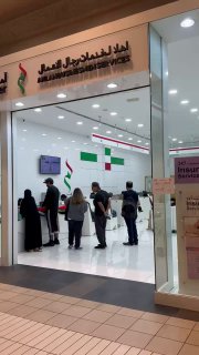 Вход в Amer Center в торговом центре: посетители у стойки обслуживания, сотрудники и общая обстановка зала для оформления Emirates ID