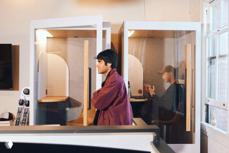 Кабинки для фокусированной работы в офисе Cursor: двое сотрудников в отдельных рабочих нишах с ноутбуками и концентрацией на задачах.