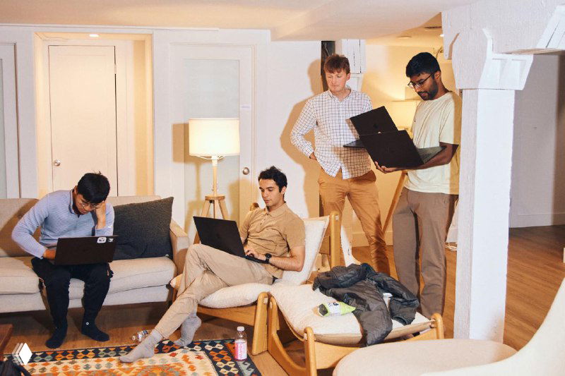 Группа разработчиков в гостиной офисного пространства Cursor: несколько человек с ноутбуками, коллективная работа и обсуждение задач в удобной зоне.