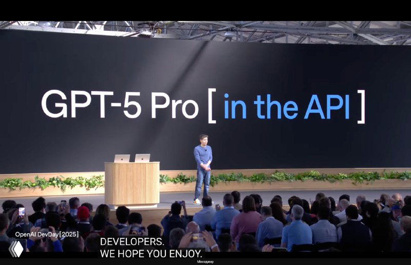 Крупный слайд «GPT-5 Pro [in the API]» на сцене; оратор стоит на фоне заголовка и аудитория наблюдает презентацию