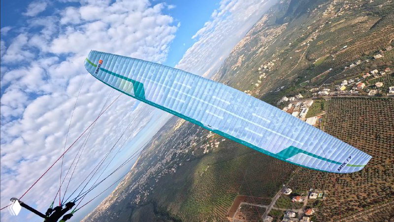 Горизонтальный вид сверху на Niviuk Artik 7P над ландшафтом; видна структура ткани, ячейки крыла и распределение нагрузки при полёте.