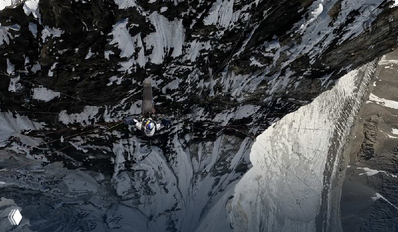 Вид сверху вниз: пилот и парапланерист над глубоким ледовым разломом; кадр демонстрирует вертикальную глубину маршрута.