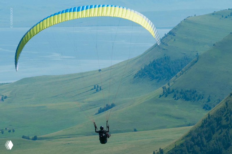 Два параплана над зелёными холмами Хакасии: дистанционные полёты вдоль склона и простор горно-степного ландшафта.
