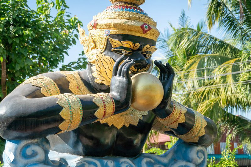 Декоративная тайская статуя с золотыми элементами на фоне пальм и зелени — культурный акцент на маршруте полётов.