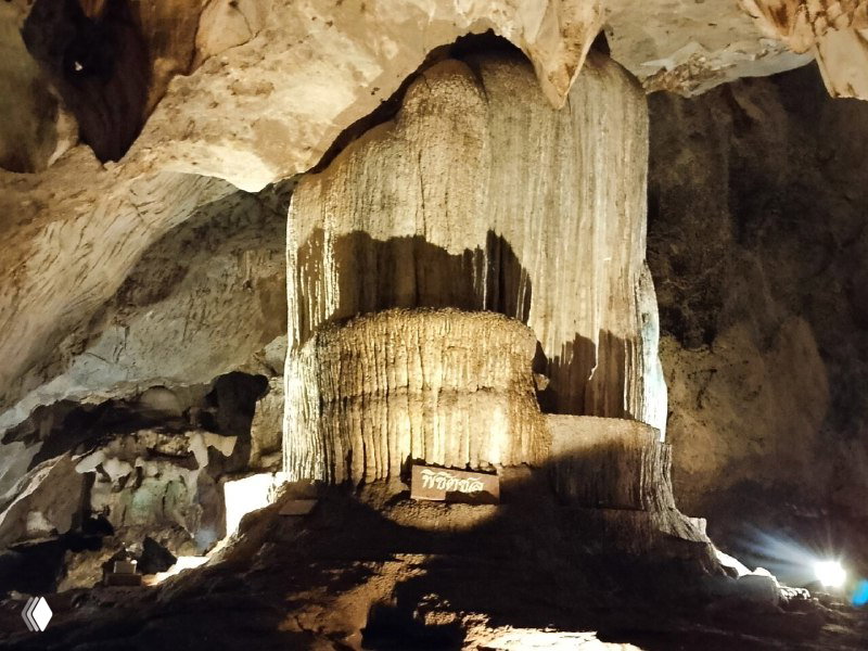 Массивный столб натёков в пещере, подсветка подчёркивает текстуру породы и масштабы карстового образования внутри пещеры.