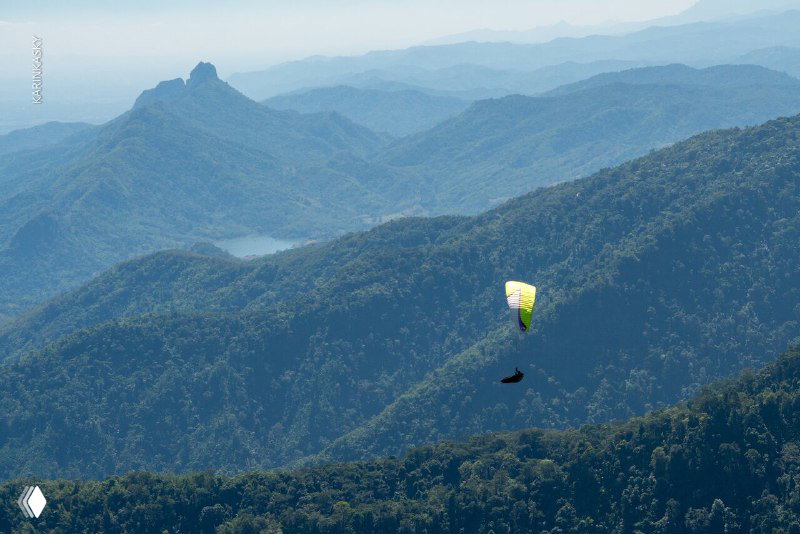 Обширный горный ландшафт Таиланда: хребты и долины, над которыми парят парапланы — иллюстрация длительных маршрутных полётов и набора налёта.