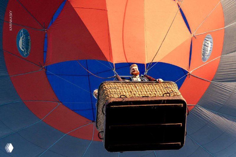 Нижняя часть воздушного шара и плетёная корзина крупным планом: видно дно корзины, укрепляющие тросы и фрагменты оболочки сверху.