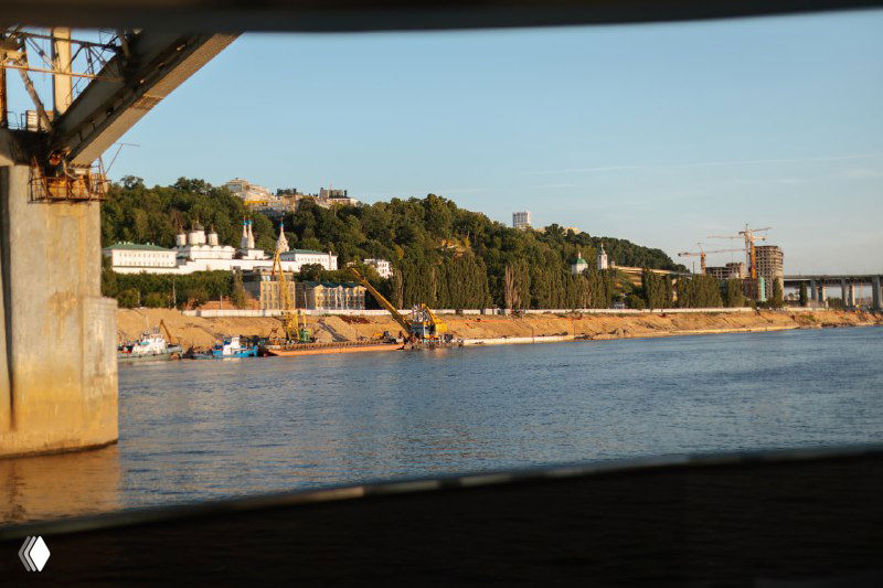Вид на реку и набережную из окна яхты: береговая зона, мост и зелёные склоны, которые обещают виды из квартир комплекса «Фордевинд».