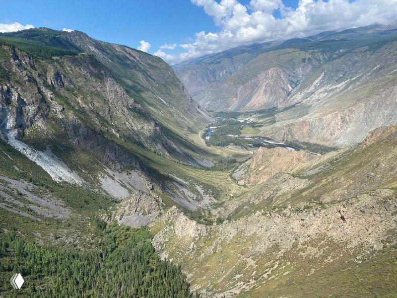 Горная долина с крутыми склонами и узкой рекой внизу — образ первозданной родной земли, дающей чувство простора и опоры.