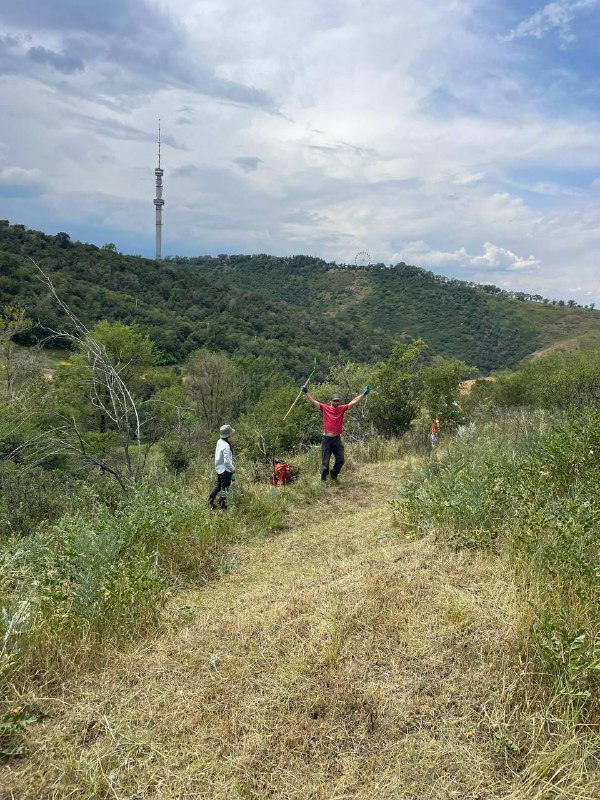 Участники на холме в Алмате с телебашней на фоне: команда осматривает трассу Athletex Race, обсуждает маршрут и снимает панораму местности.