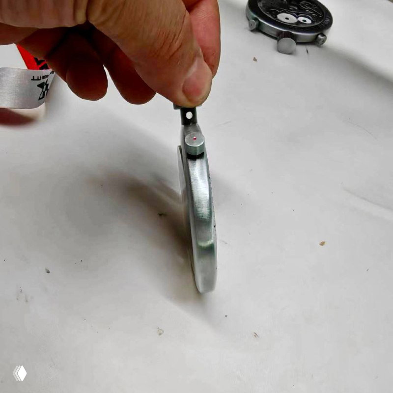 Боковой вид медали Road Race в руке участника: тонкий металлический корпус, видна боковая грань и крепление, фото на светлом фоне.