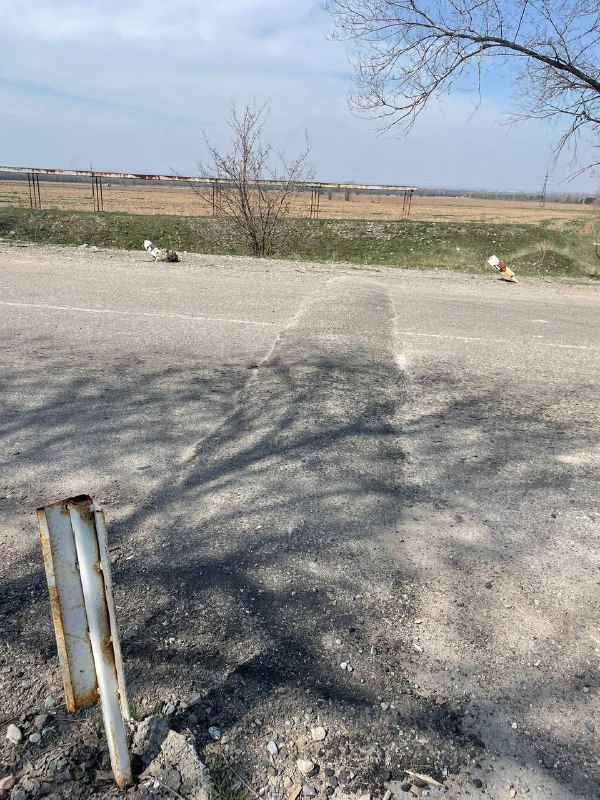 Участок дороги с видимыми заплатами и металлическим столбиком у обочины; изменение поверхности асфальта перед разворотной точкой.