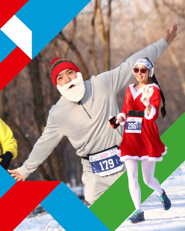 Бегуны в новогодних костюмах: мужчина с бородой и женщина в платье Деда Мороза проходят трассу на зимнем забеге в лесопарке.