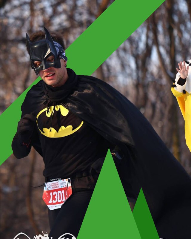 Участник в костюме Бэтмена бежит по зимней дороге в числе других спортсменов на новогоднем марафоне в Центральной Азии.