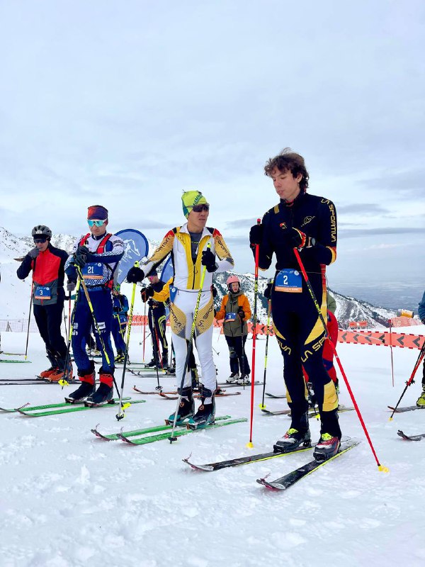 Стартовые позиции лидеров среди мужчин: спортсмены в лыжном снаряжении готовятся к подъему в дисциплине Вертикальный километр.