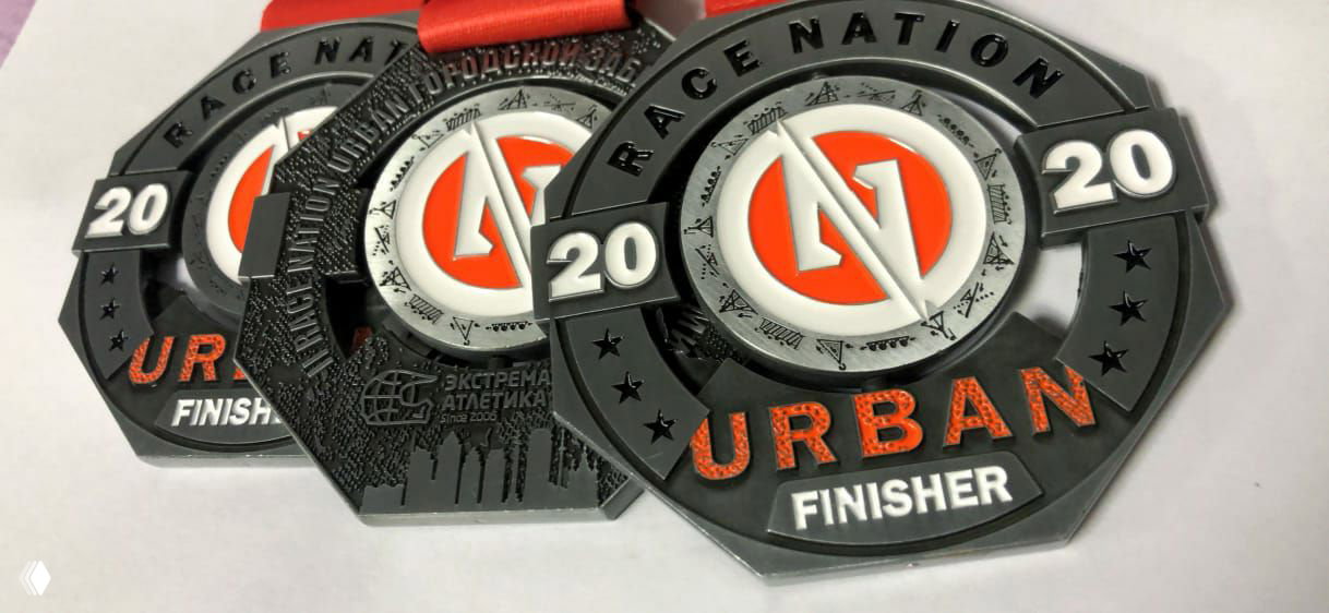 Крупный план медалей Race Nation Urban II в чёрно-оранжевой гамме с лентами; детализированная рельефная поверхность и надписи «URBAN», «FINISHER».