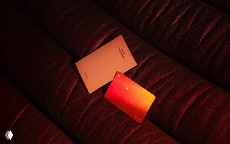 Фотография на диване: карточка и градиентный стикер в теплой подсветке, отражающие визуальный язык Mana в интерьерной подаче.