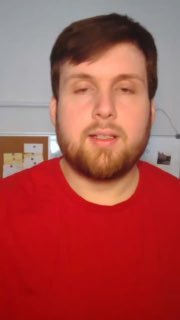 Кадр из видео: преподаватель канала в красной футболке объясняет подход к системной подготовке к ОГЭ; видна стена и предметы кабинета на заднем плане.