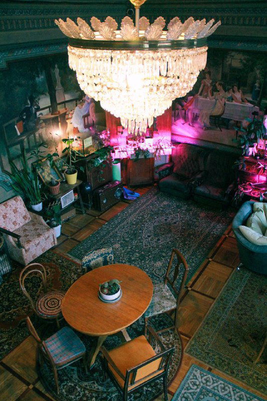 Вид сверху на бальный зал с круглым столом, зоной бара и разноцветной подсветкой, создающей перформативную атмосферу вечера.