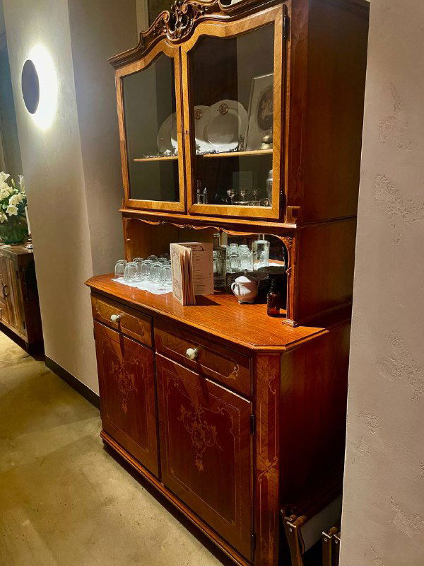 Антикварный буфет с сервизом и стеклянной посудой — небольшой уголок артефактов той эпохи в оформлении заведения «Медведь».