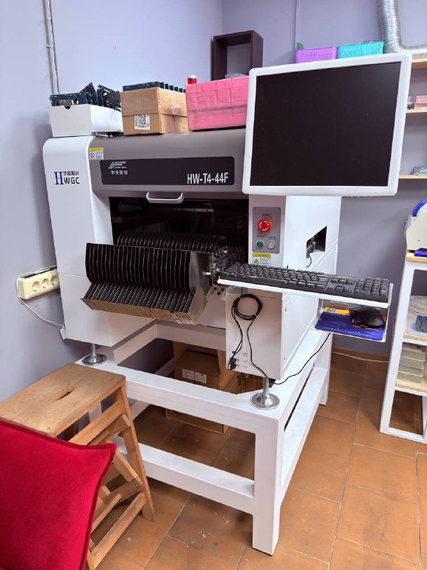 Промышленное оборудование с монитором и системой автоматической подачи компонентов для сборки электронных модулей и плат.