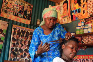 Небольшая парикмахерская в Мьяичине, Мьянма: внутренняя обстановка, постеры с образами и деревянная конструкция салона в сельской местности.