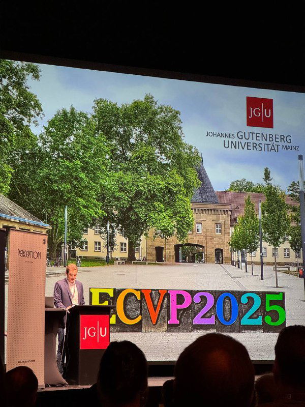 Экран с логотипом JGU и крупной цветной надписью «ECVP2025» на сцене конференции в Майнце, силуэты аудитории внизу кадра.