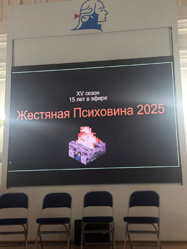Экран сцены с надписью «Жестяная Психовина 2025» и пиксельным изображением — титульный слайд мероприятия, перед рядом стульев.