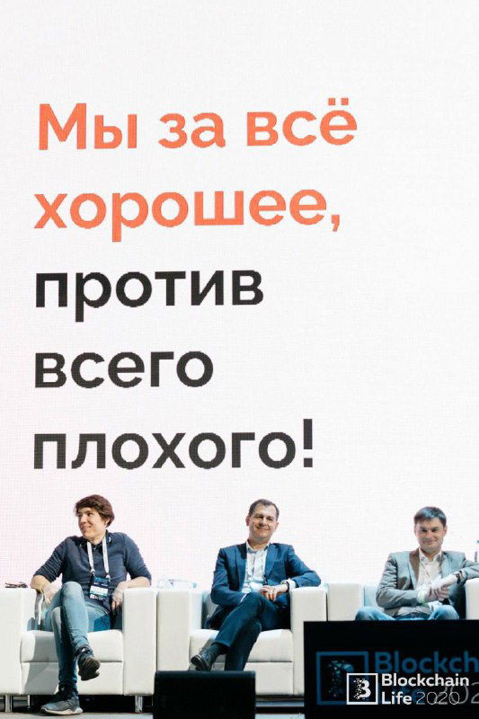Вертикальный баннер с надписью «Мы за всё хорошее, против всего плохого!» и трое спикеров, сидящих на диванах на сцене на фоне брендирования мероприятия.