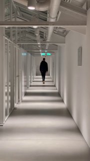Фото коридора с человеком вдалеке; пустота и перспектива подчёркивают ощущение одиночества и бессмысленности.