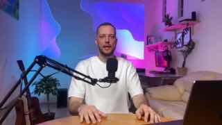 Кирилл Поляков в домашней студии: сидит за столом перед микрофоном и ноутбуком, говорит в камеру на фоне цветной подсветки.