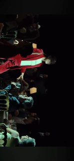 Сцена и зал: человек в красном пиджаке на сцене и зрители в первом ряду — документальный кадр с премьеры или обсуждения после показа.