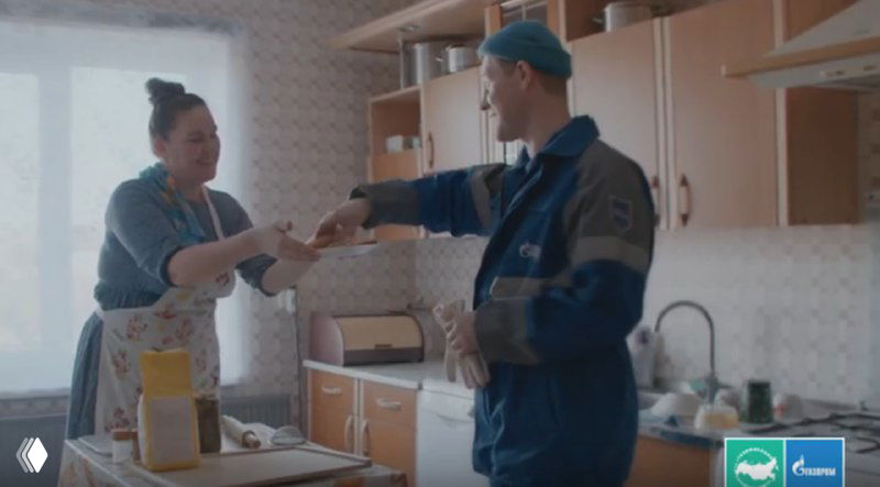 Кадр из современной рекламы с курьером, передающим посылку женщине на кухне — пример апелляции к повседневным эмоциям и рутинным сюжетам.