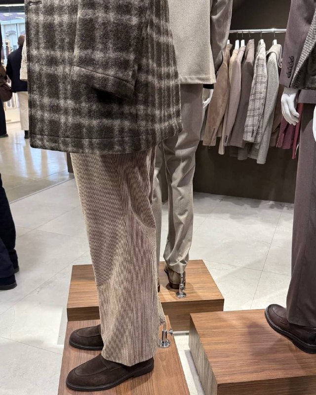 Крупный план манекена в брюках и туфлях коллекции DIGEL Move: фактурные светлые ткани, мягкая драпировка и нейтральная палитра в экспозиции Pitti Uomo.