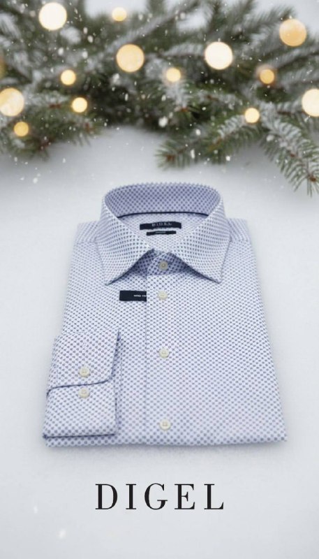 Светлая сорочка с мелким рисунком аккуратно сложена на снегу, рядом праздничные огни и хвоя — рекламный кадр, подчёркивающий универсальность модели DIGEL.