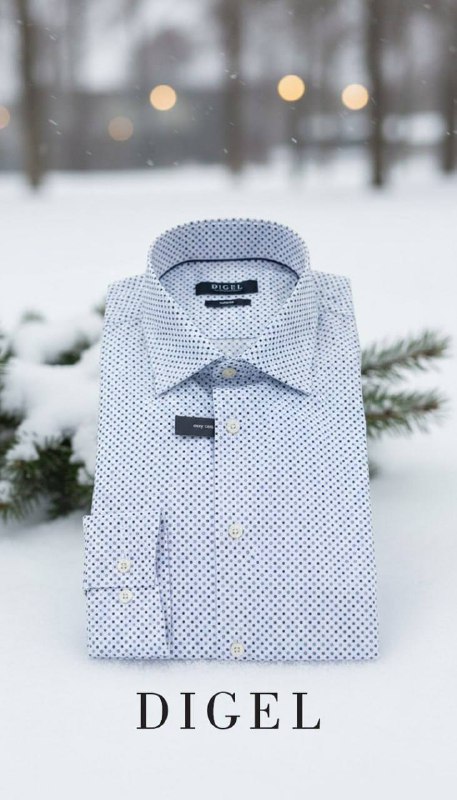 Светло-голубая мужская сорочка в сложенном виде на снежном фоне с размытыми деревьями позади; рекламный снимок коллекции DIGEL для зимнего сезона.