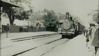 Чёрно‑белая фотография с поездом на станции и людьми на платформе — ретро-кадр, создающий атмосферу метафоры о кампании как кино и рабочих сценах в фарме.